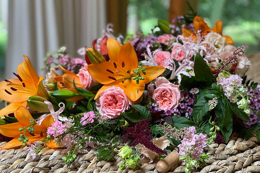 Hand tied bouquet of flowers on seagrass coffin