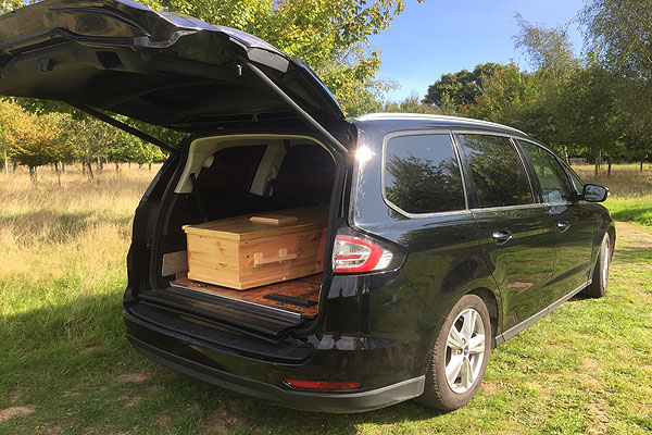 Informal hearsette vehicle with coffin at Oakfield Wood Natural Burial Ground at Shamley Green